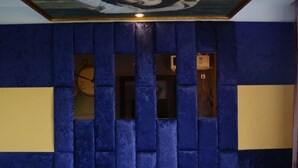 A room with a blue textured wall, a clock, and a ceiling artwork. - Chenxiang Fashion Hostel (Shanghai)