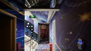 A hallway with a colorful, patterned floor and walls featuring space-themed designs. - Chenxiang Fashion Hostel (Shanghai)