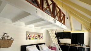 Ein Schlafzimmer mit Bett, Nachttisch, Lampe und einem Bild an der Wand.