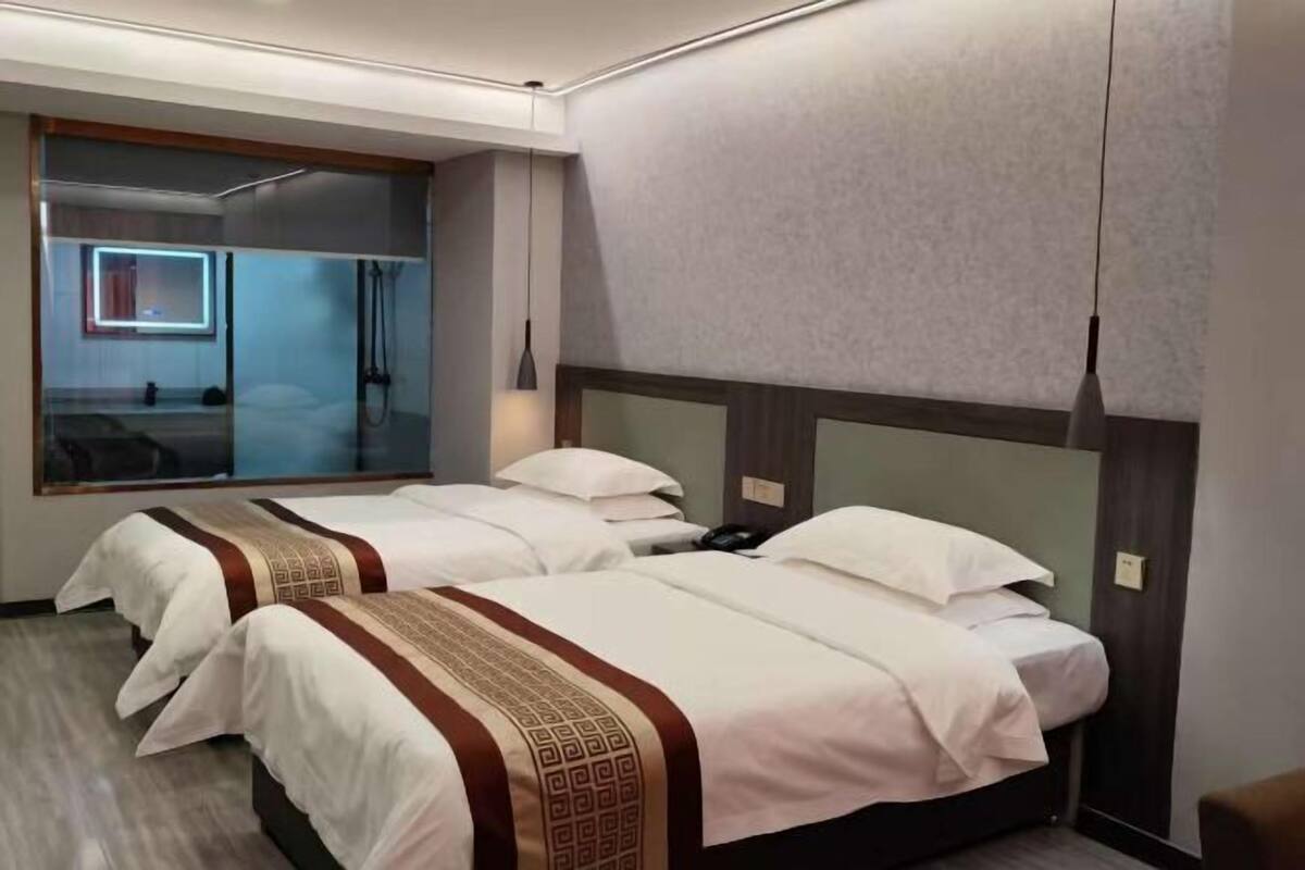 Habitación de hotel con dos camas, un espejo grande y un diseño moderno.