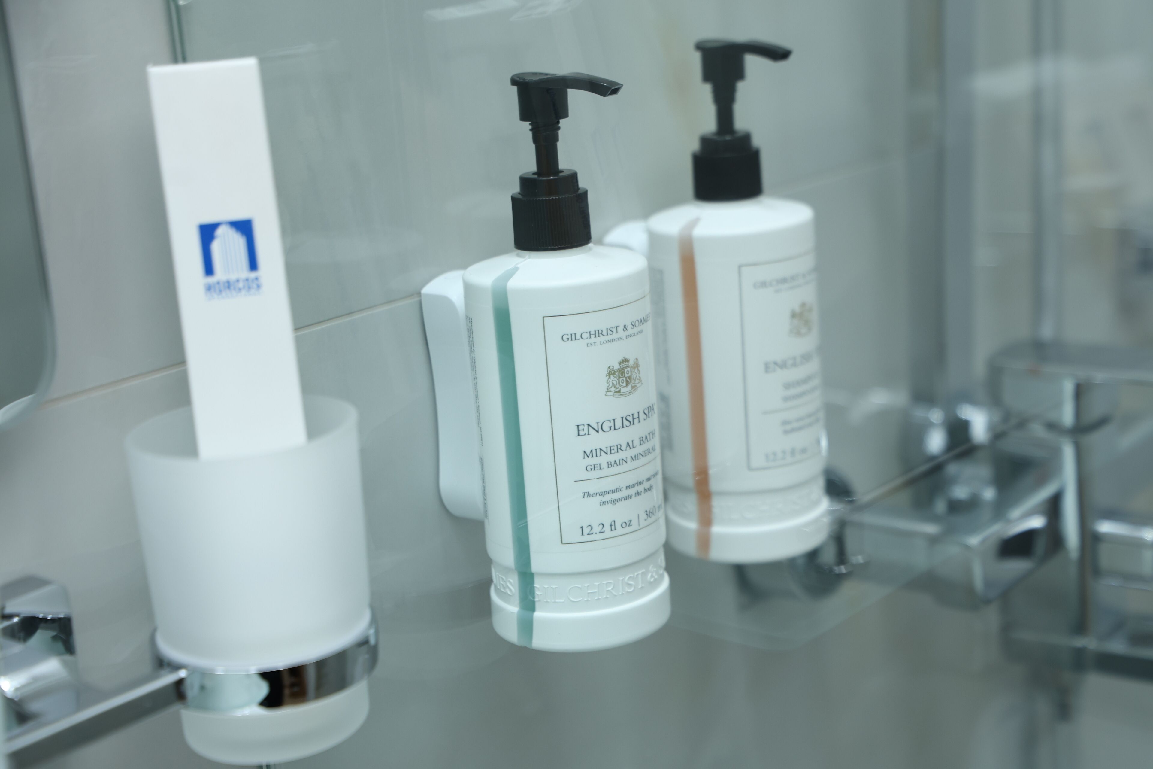 Three toiletry bottles on a bathroom counter.
