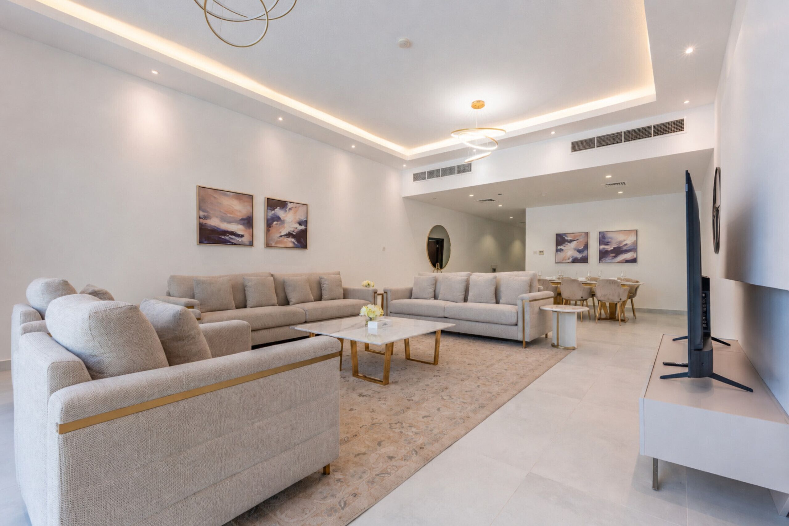 A modern living room with a sofa, coffee table, and a TV.