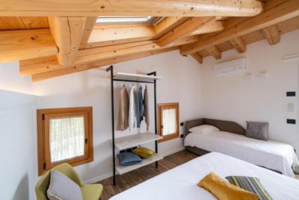 A bedroom with two beds, a wardrobe, and a skylight.