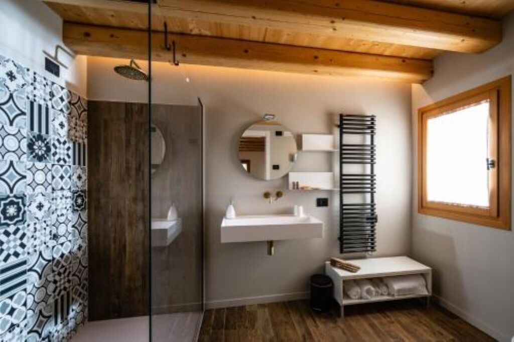 Een moderne badkamer met een douche, wastafel en spiegel.