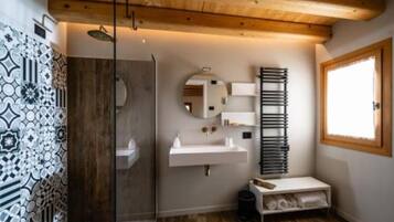 Een moderne badkamer met een douche, wastafel en spiegel.