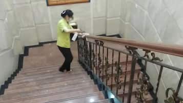A person descending a marble staircase with a handrail and a metal railing.