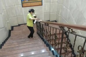 A person descending a marble staircase with a handrail and a metal railing. - Liaocheng Yuelu Hotel (Liaocheng)