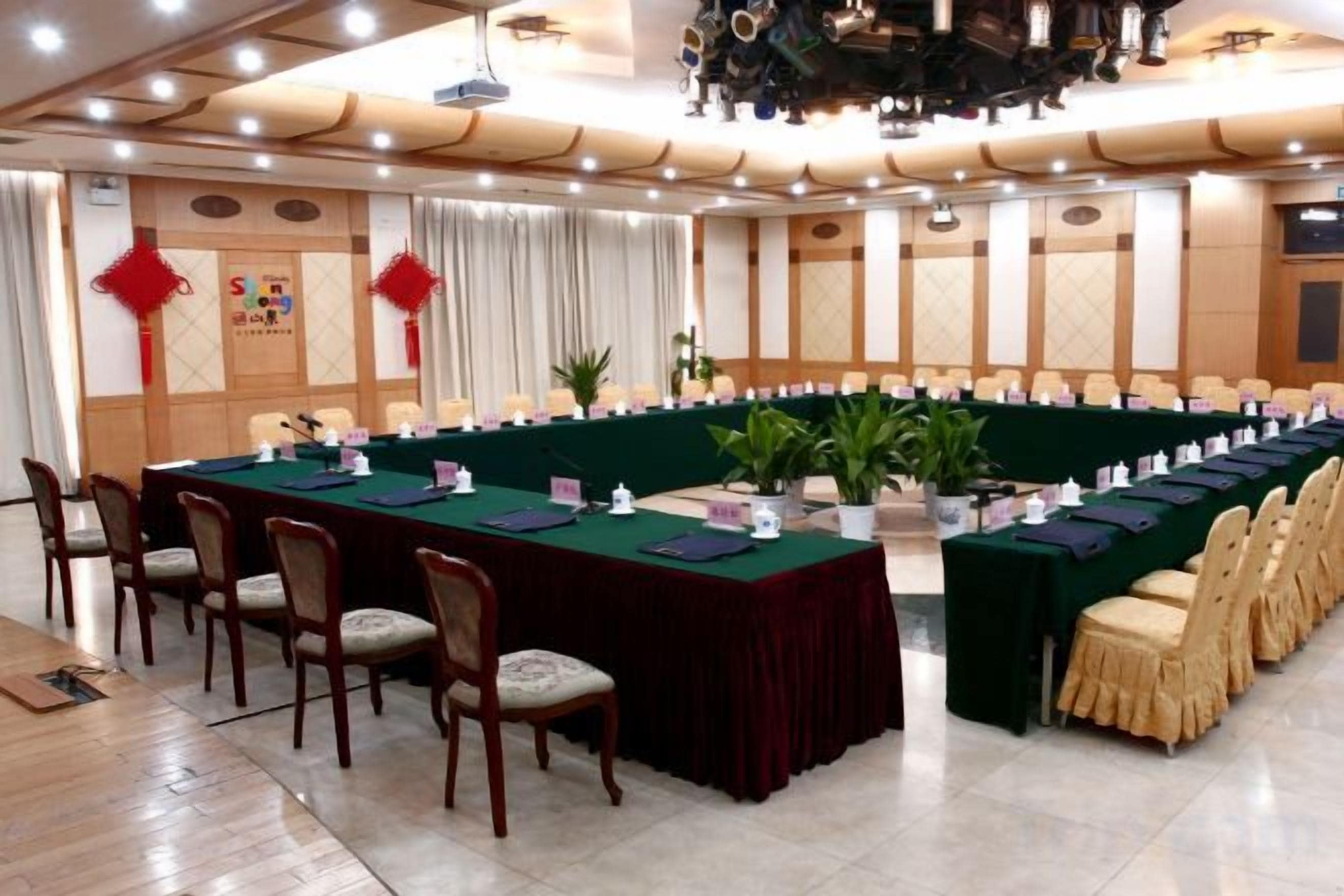 A conference room with a long table, chairs, and a stage.
