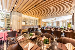 Un restaurante con paneles de techo de madera, asientos de cuero y una zona de bar con botellas de vino.