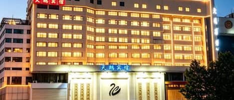 Un hotel de varios pisos con una entrada destacada y señalización.