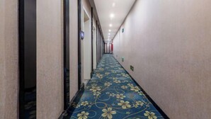 Un pasillo largo y estrecho con alfombra azul con estampado floral.