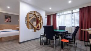 Una habitación de hotel con una cama, un escritorio con ordenador, una mesa de billar y un adorno circular grande en la pared.