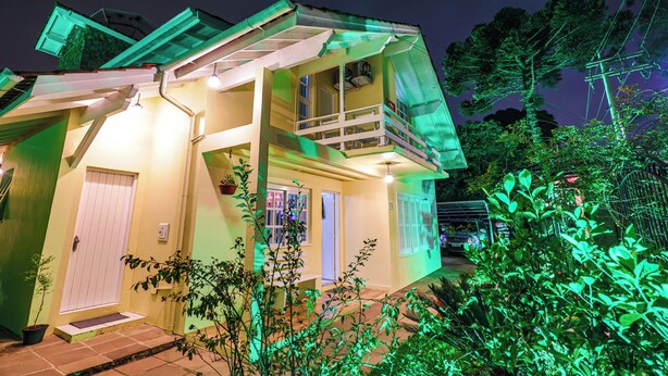 A two-story house with a balcony, a door, and a window. - Pousada Maison Suisse  (Canela)