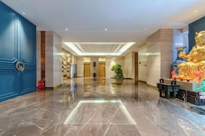 A hotel lobby with a marble floor, a reception desk, and a statue on the right. - Echarm Plus Hotel Taiyuan Wanda Plaza Railway Station Store (Taiyuan)