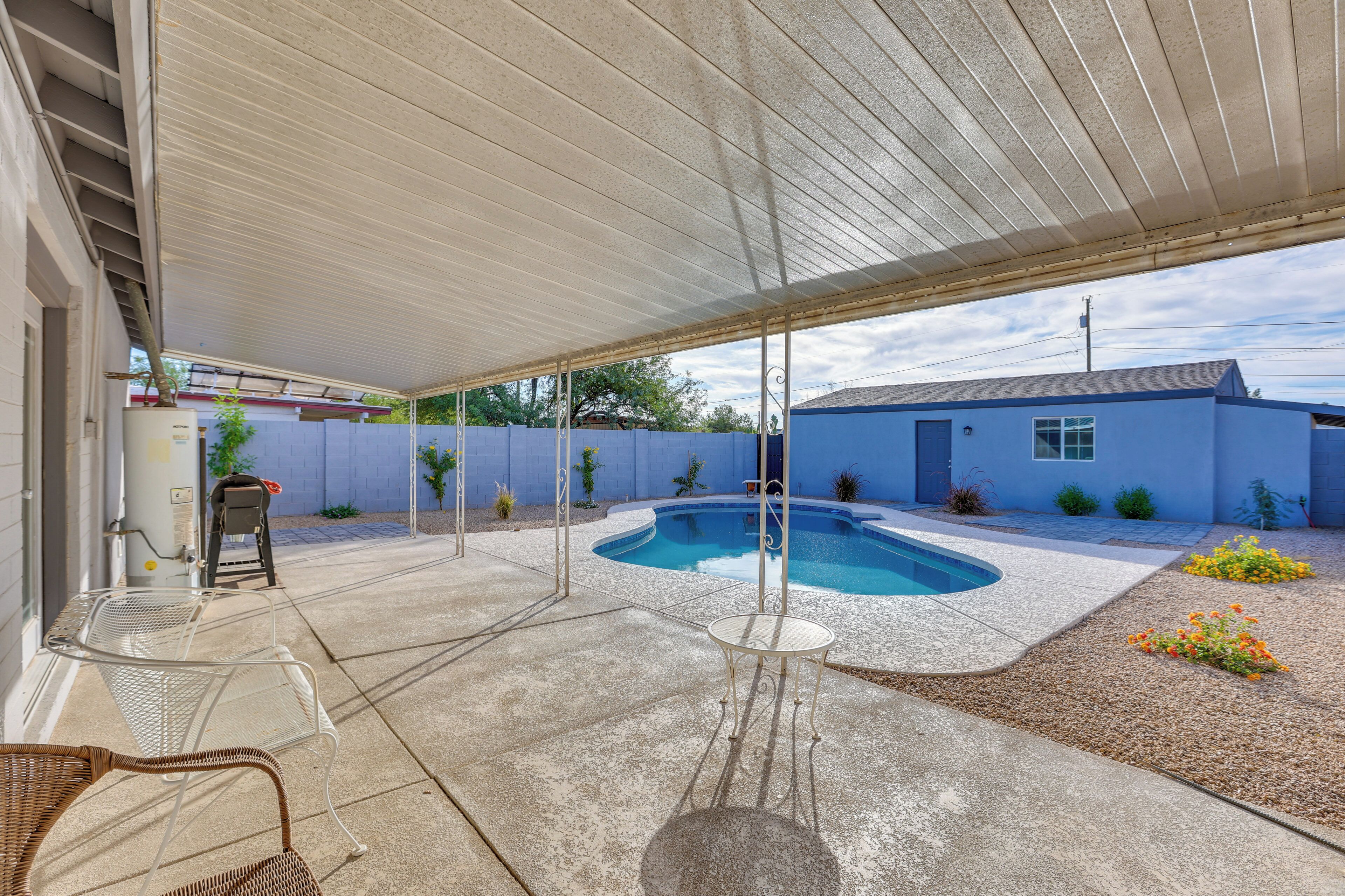Un patio abrité avec une piscine, des sièges d’extérieur et un petit jardin.