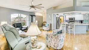 A spacious living room with a sofa, a chair, a lamp, and a decorative table.