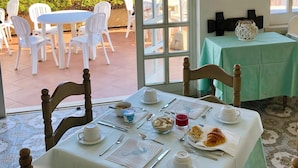 A dining area with a table set for two, a view of the sea, and a green tablecloth. - HOTEL ACQUAMARINA (Portoferraio)