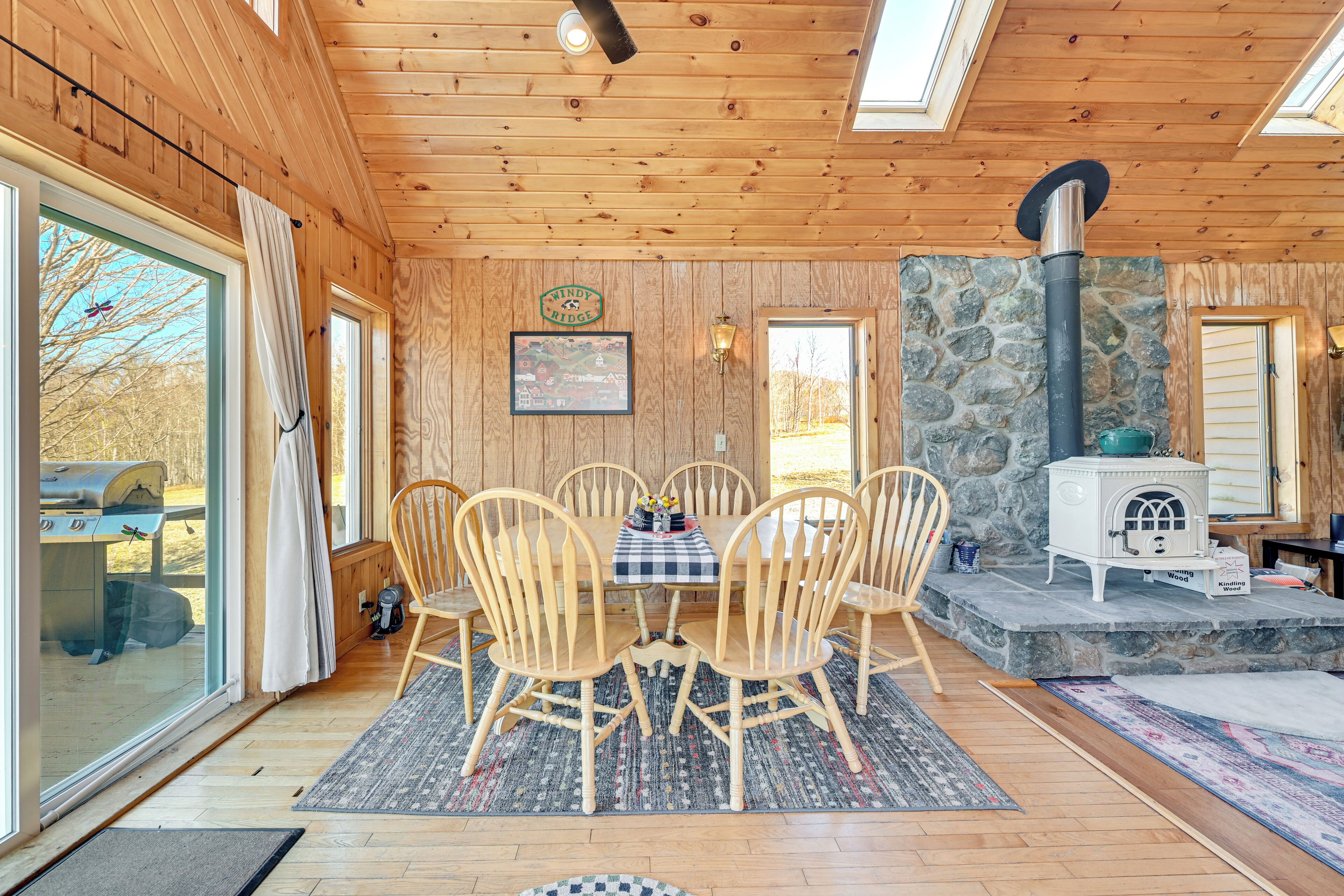 Un intérieur en bois avec une cheminée en pierre, une table à manger et des chaises.
