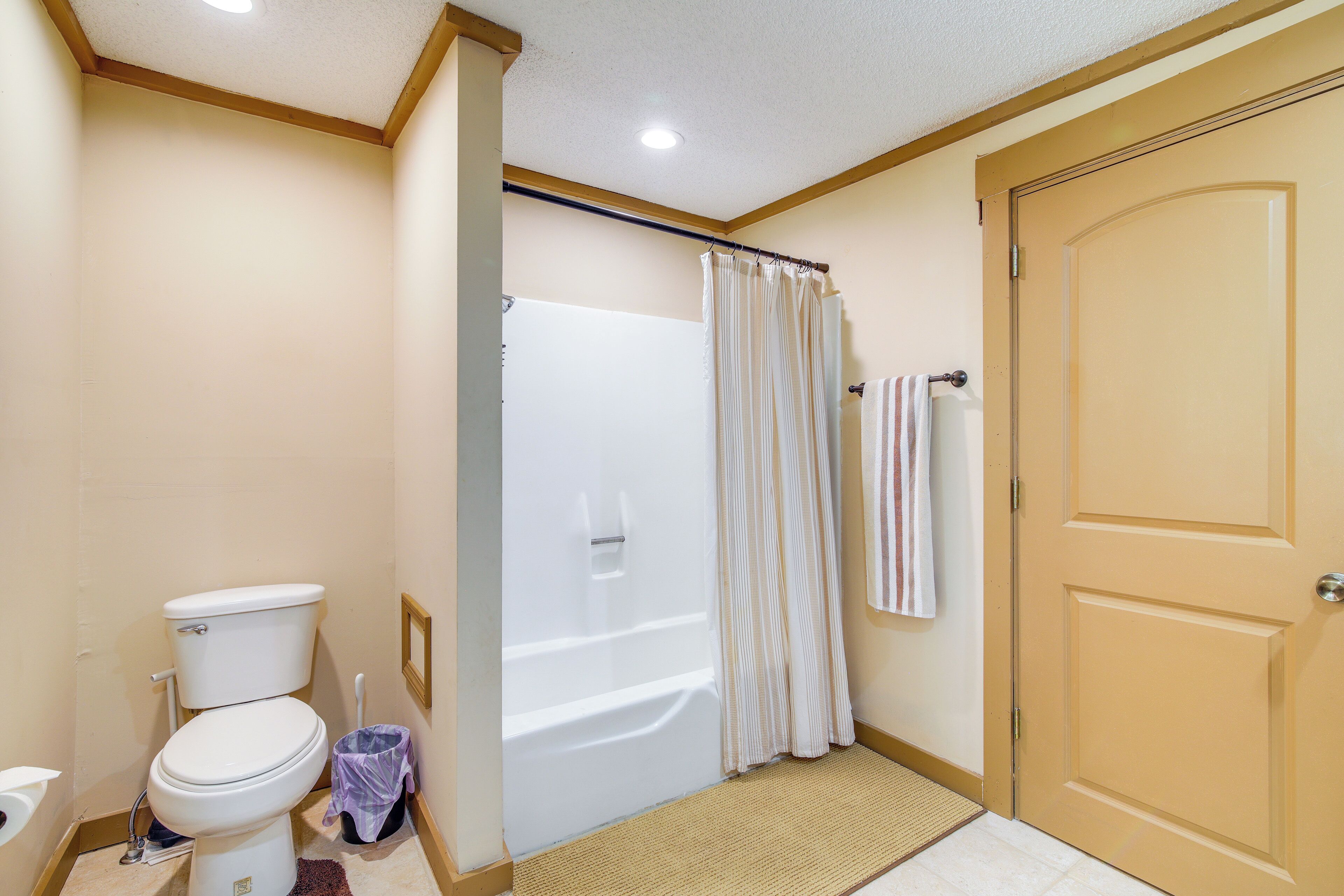 Un baño con inodoro, ducha y puerta.