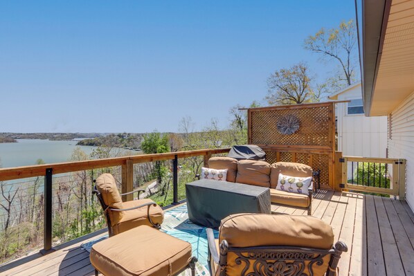A deck with outdoor furniture, a view of a lake, and a wooden fence. - The Best Views on Beaver Lake! Home w/ Deck & BBQ (Rogers)