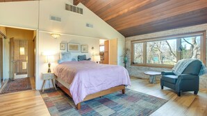 A bedroom with a large bed, a chair, a small table, and a view of the outdoors. - Spacious & Updated Farmhouse in Yellow Springs (Yellow Springs)