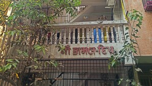 Un bâtiment avec une enseigne dans une langue locale, des balcons dotés de garde-corps et des unités de climatisation.