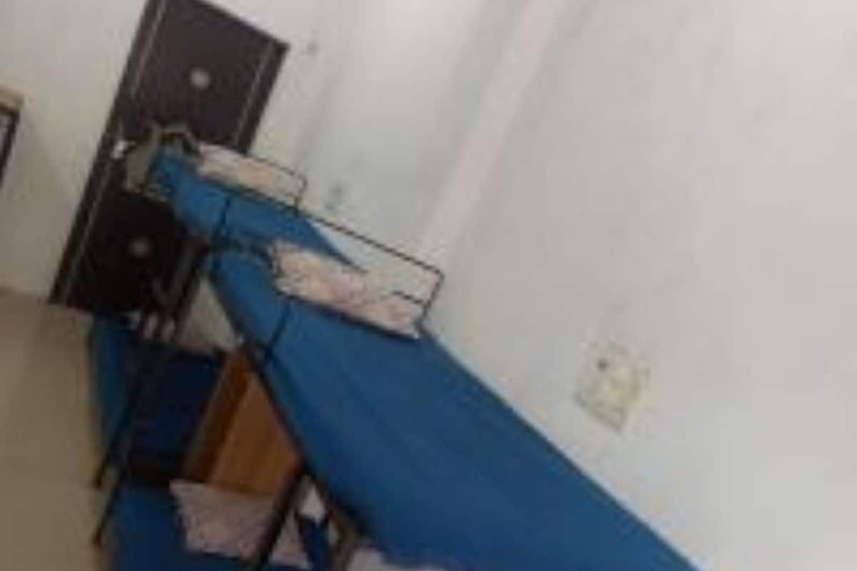 Un dormitorio con literas, un escritorio y una silla.
