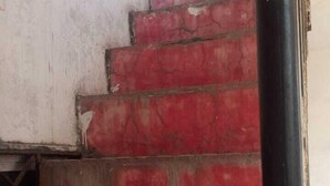 Un escalier aux marches rouges menant à un palier.