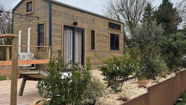 A modern house with a wooden exterior, a front door, and a small porch area. - Comfortable Tiny House in Saulges in the heart of nature. (Saulges)