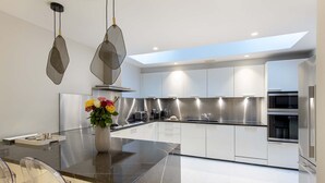 A modern kitchen with white cabinets, stainless steel appliances, and a central island.