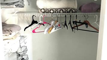 Un placard avec des étagères, une tringle pour suspendre les vêtements et un porte-chaussures.