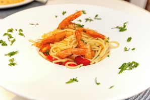 Un plato de espagueti con camarones y verduras.