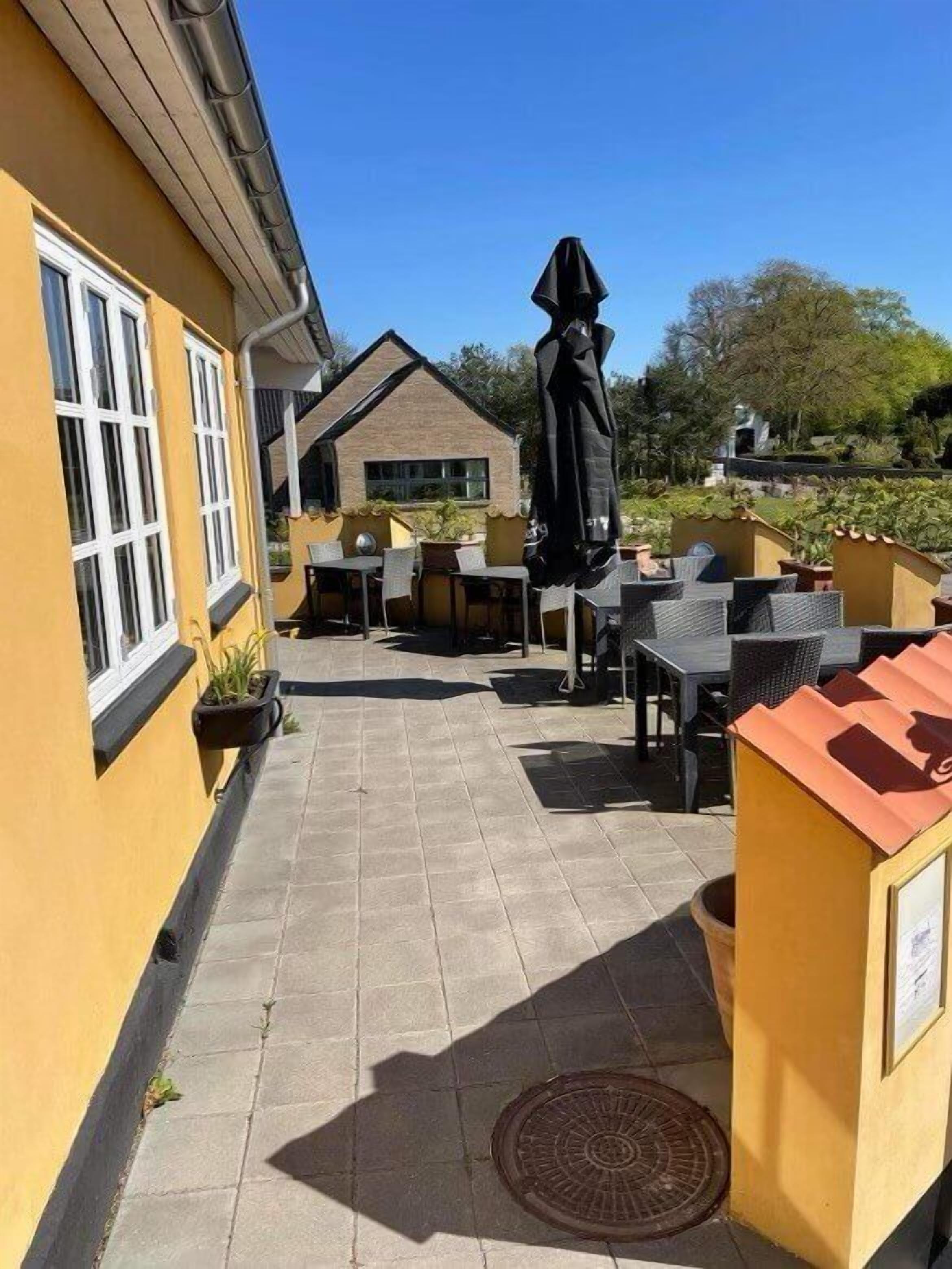 Un patio con mobiliario exterior y un edificio al fondo.