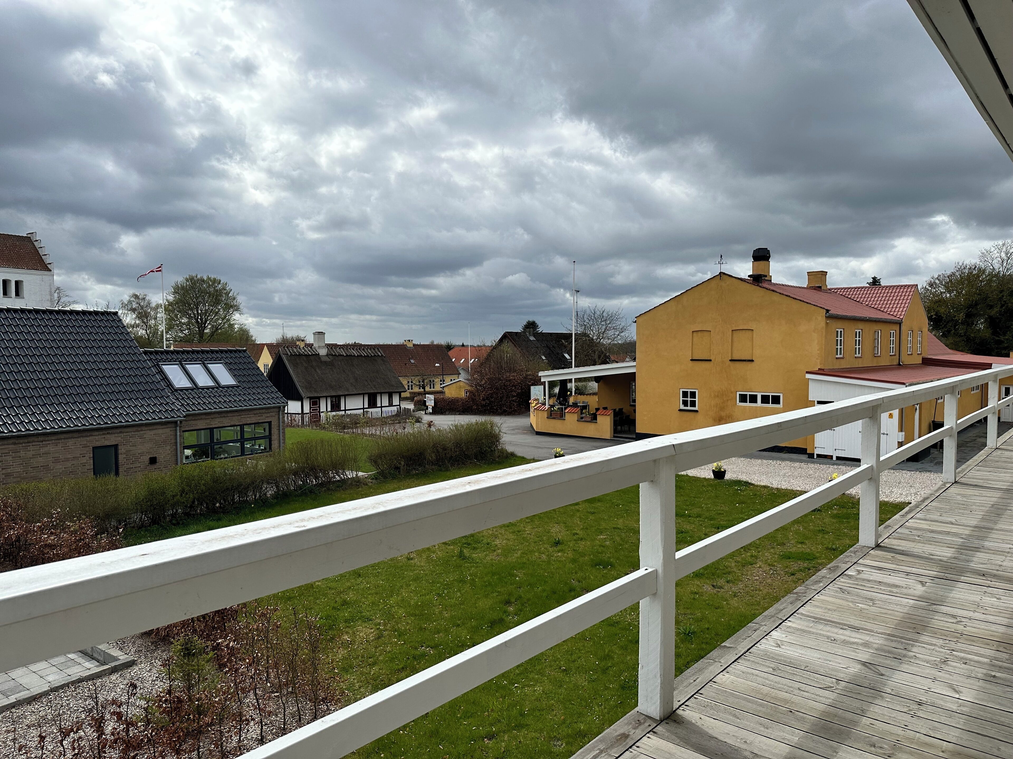 A residential area with houses, a wooden deck, and a grassy lawn.