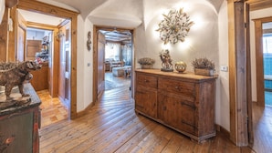 A wooden hallway with a rustic decor, including a cabinet with decorative items and a dog statue. - Casa Cristallino, in the town center with panoramic view (Cortina d´Ampezzo)