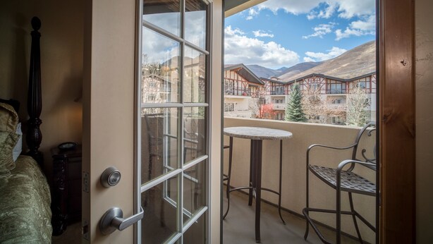 A balcony with a view of a mountainous landscape and a building with red accents. - Villa 2082 2 Bed 2 Bath Full Kitchen 2 Bedroom Villa (Midway)