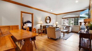 A cozy living room with a wooden dining table, sofas, and a large window offering a mountain view. - Villa 2082 2 Bed 2 Bath Full Kitchen 2 Bedroom Villa (Midway)
