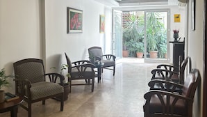 A spacious lobby with a modern ceiling design, a seating area with chairs and a table, and a view of the outdoors through large glass doors. - Alaya Apart Otel (Alanya)