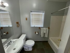 Bañera con ducha, toallas, jabón, shampoo