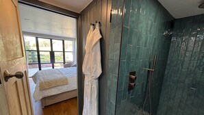 A bathroom with a shower, a bathtub, and a window.
