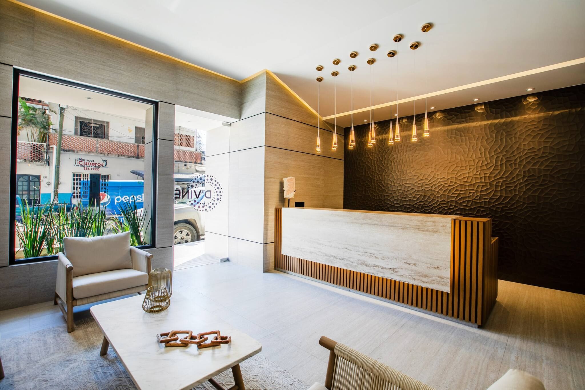 A modern reception area with a reception desk, seating, and a view of the street.