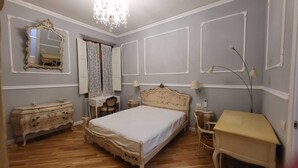 A bedroom with a large bed, a dresser, a vanity, and a desk. - ELEGANT APARTMENT IN THE HEART OF FLORENCE, PIAZZA SIGNORIA (Firenze)