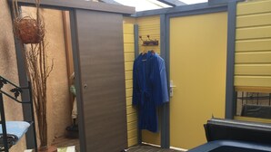 A hot tub, wooden deck, and a yellow wall with a blue robe hanging. - Villa sleeps 14 with heated pool pets welcome (Issel)