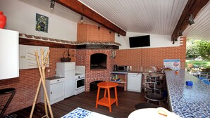 A kitchen with a brick oven, white cabinets, and a bar area. - Villa sleeps 14 with heated pool pets welcome (Issel)