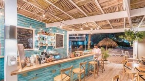 A bar area with a wooden ceiling and a blue wall. There are bar stools and a counter with various items. - Playa Turquesa D403_80Mbps_Private Beach Access_Pools (Bavaro-Punta Cana)