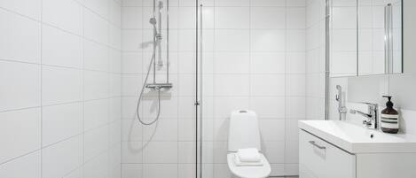 A modern bathroom with a shower, toilet, and vanity.