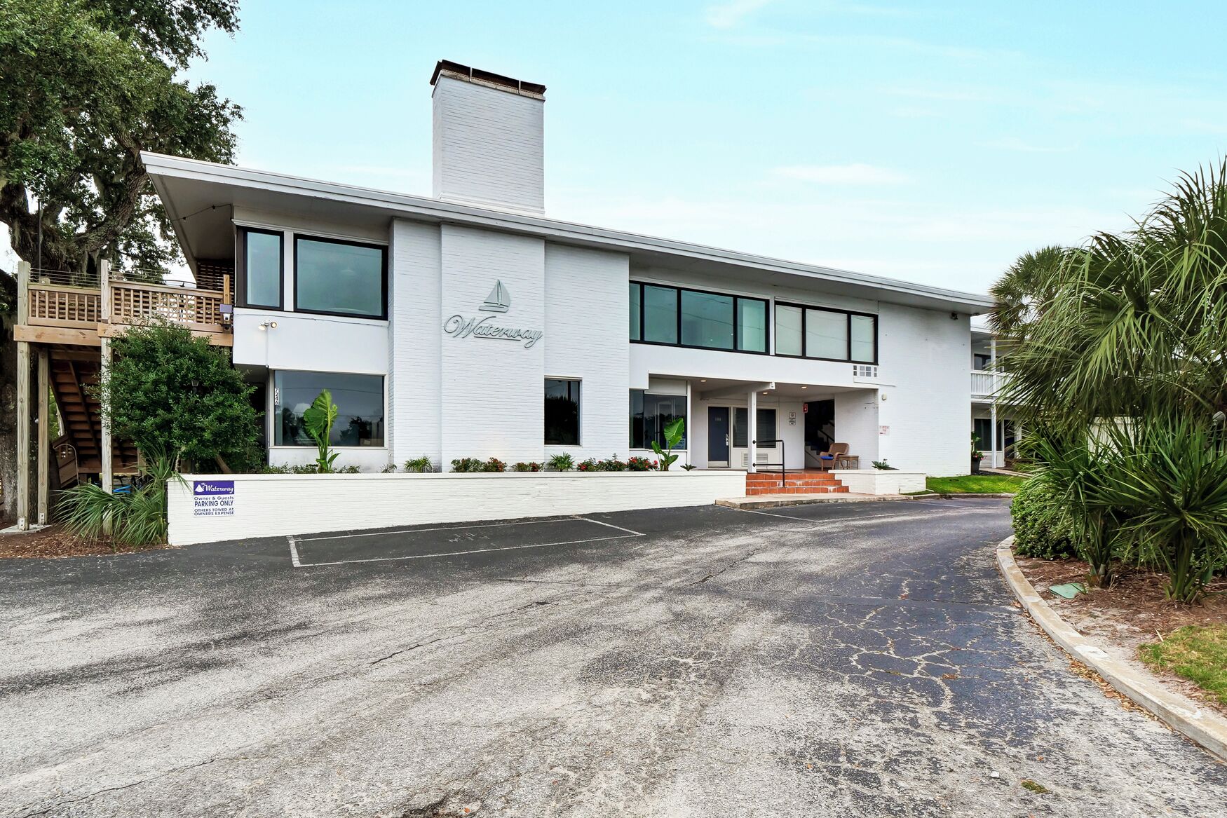 Un bâtiment moderne à la façade blanche, doté de grandes fenêtres et d’une enseigne indiquant qu’il s’agit d’un hôtel.