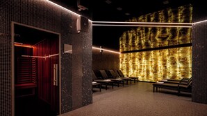 Une salle de spa avec un mur carrelé, une porte rouge et plusieurs fauteuils.