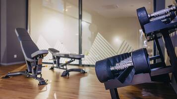 A gym with exercise equipment, including dumbbells and benches.