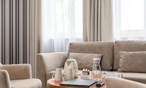 A modern living room with a sofa, a coffee table, a kettle, a bottle, and a remote control. - Platinum Adults (Szklarska Poreba)